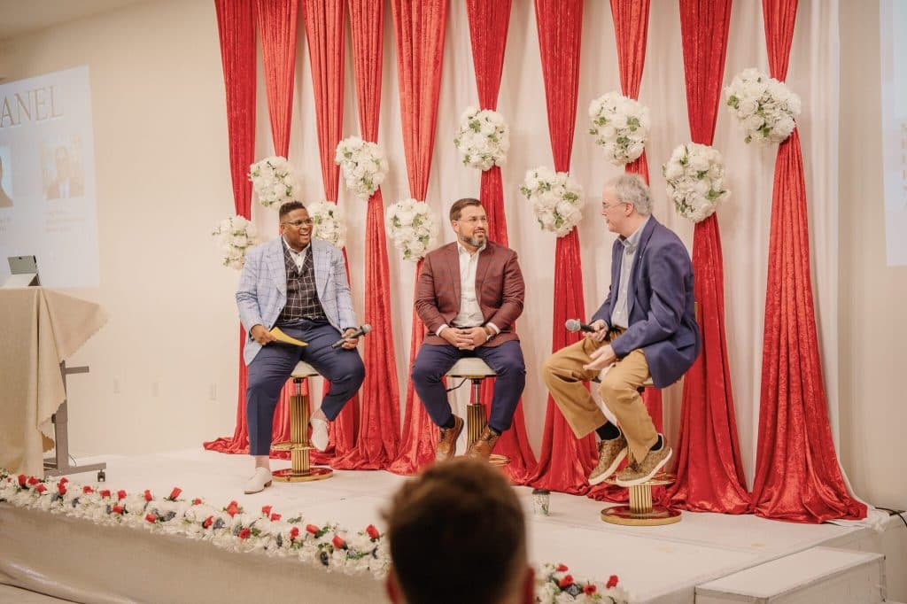 Panel of speakers seated on stage at a Pathways client event
