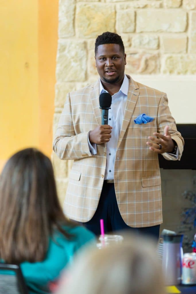 Marques Miles speaking with a microphone at a seminar