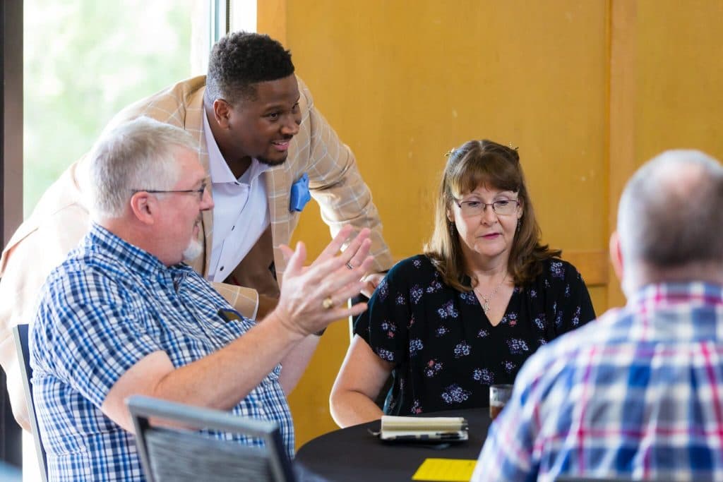 Marques Miles talking with guests at their table